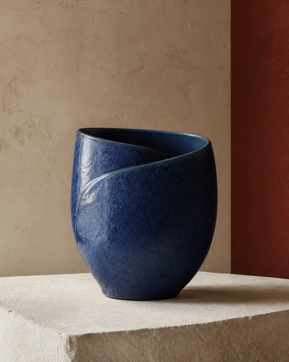 Cobalt-blue folded vessel on a pale stone plinth