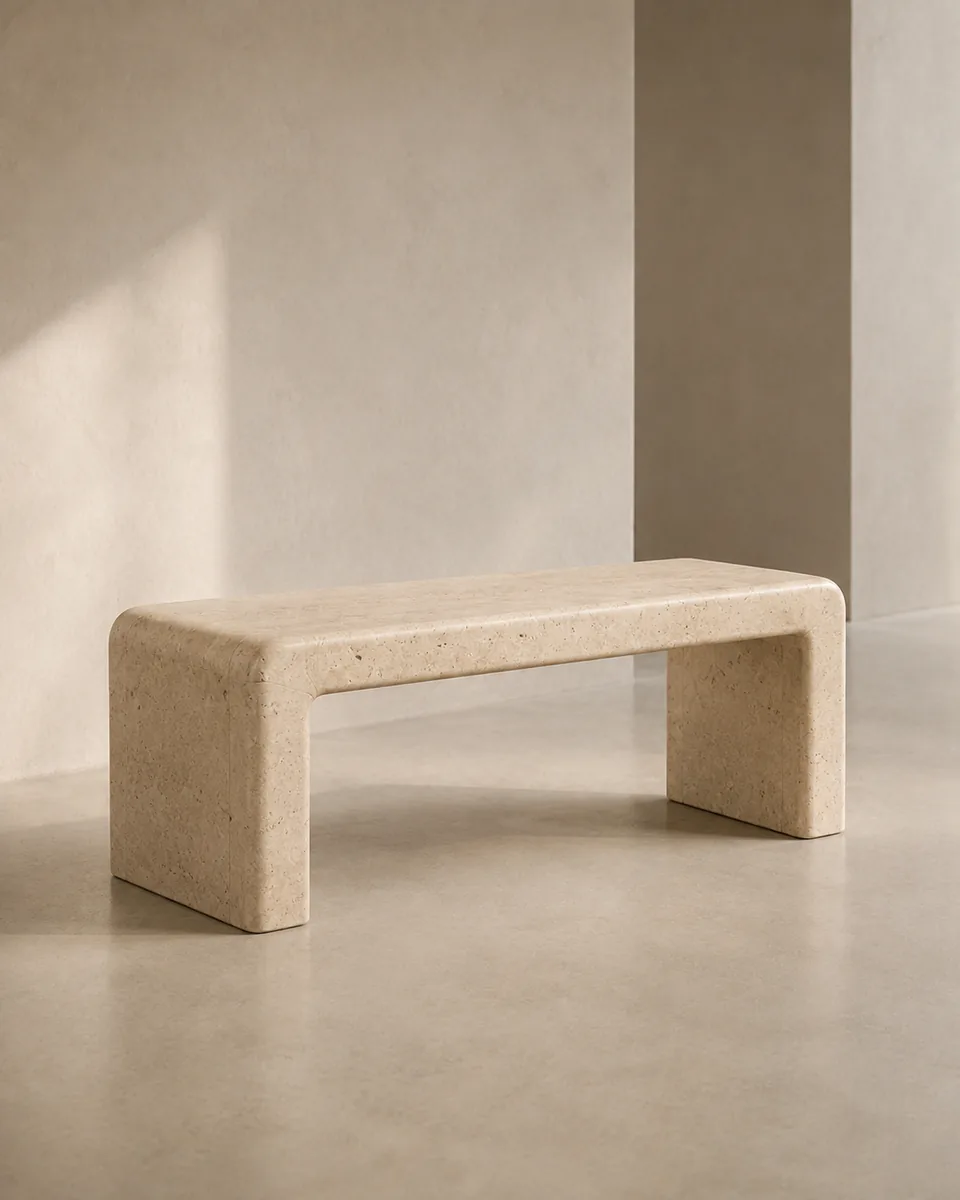 Chalk-coloured mineral bench cast as one continuous form in a sunlit studio setting